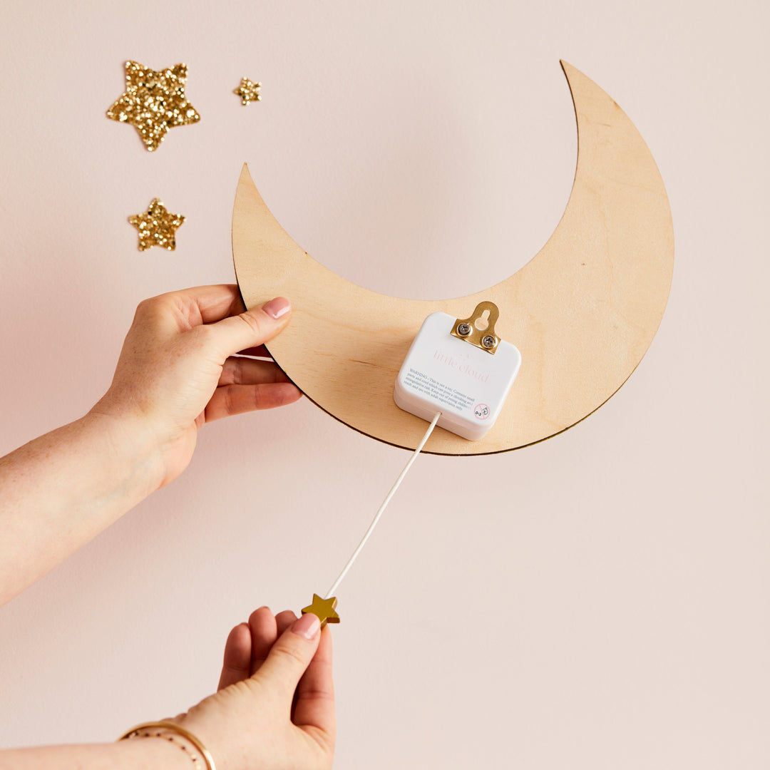 a person is holding a string attached to a wooden moon